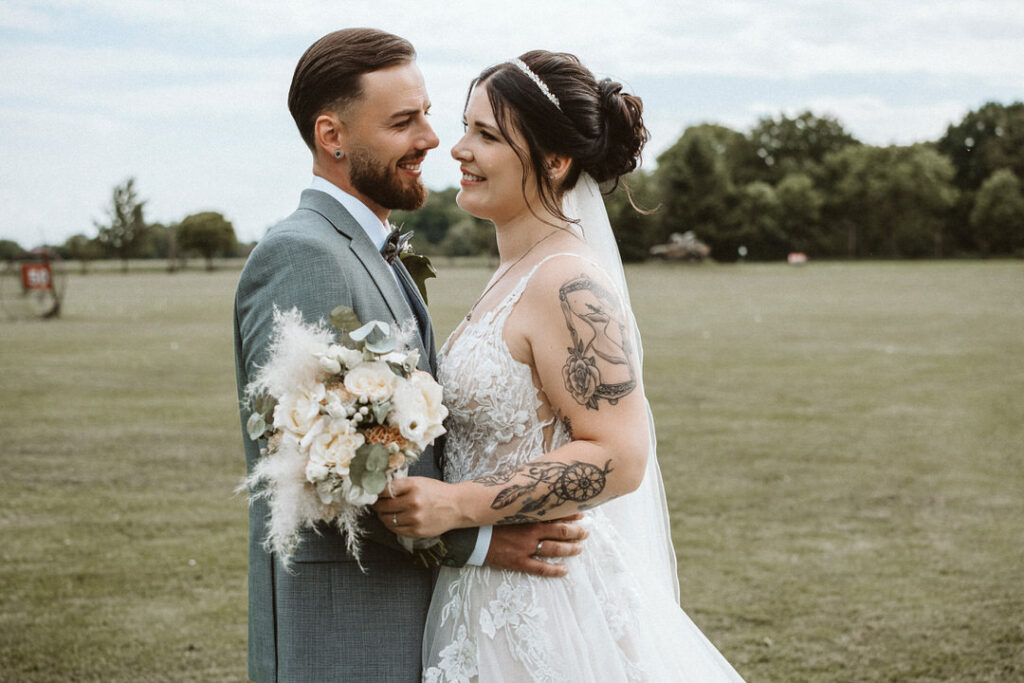 Braut und Bräutigam stehen voreinander auf dem Feltgenhof in Moers