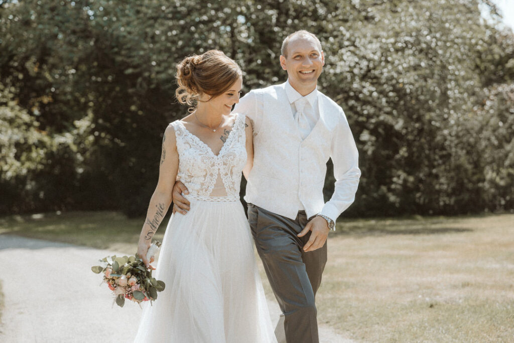 Braut und Bräutigam laufen zusammen im Stadtpark Moers