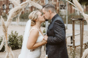 Braut und Bräutigam küssen sich bei der Hochzeit in Dinslaken