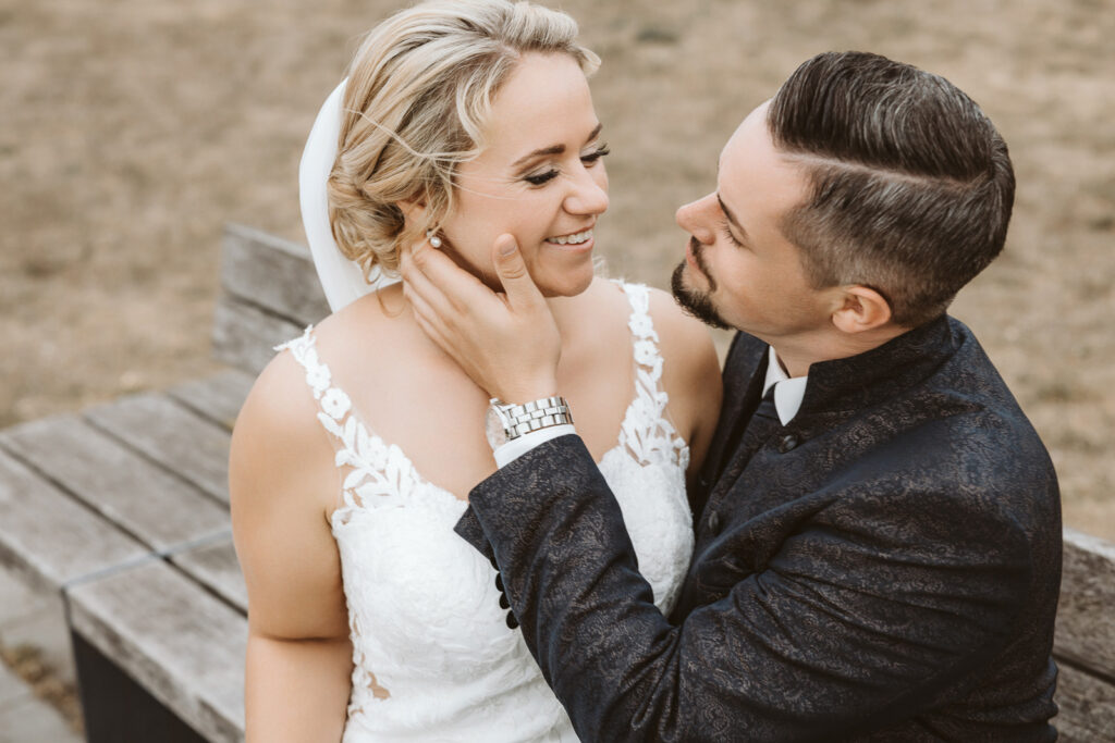 Braut und Bräutigam sitzend auf der Bank an der Zeloh in Dinslaken