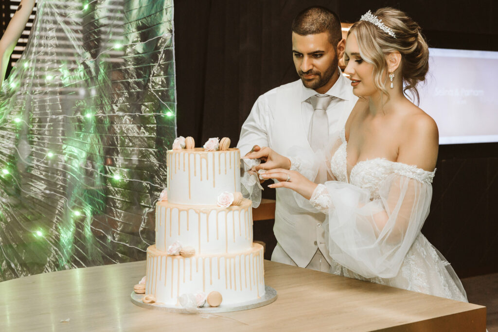 Hochzeitstorte wird vom Brautpaar angeschnitten