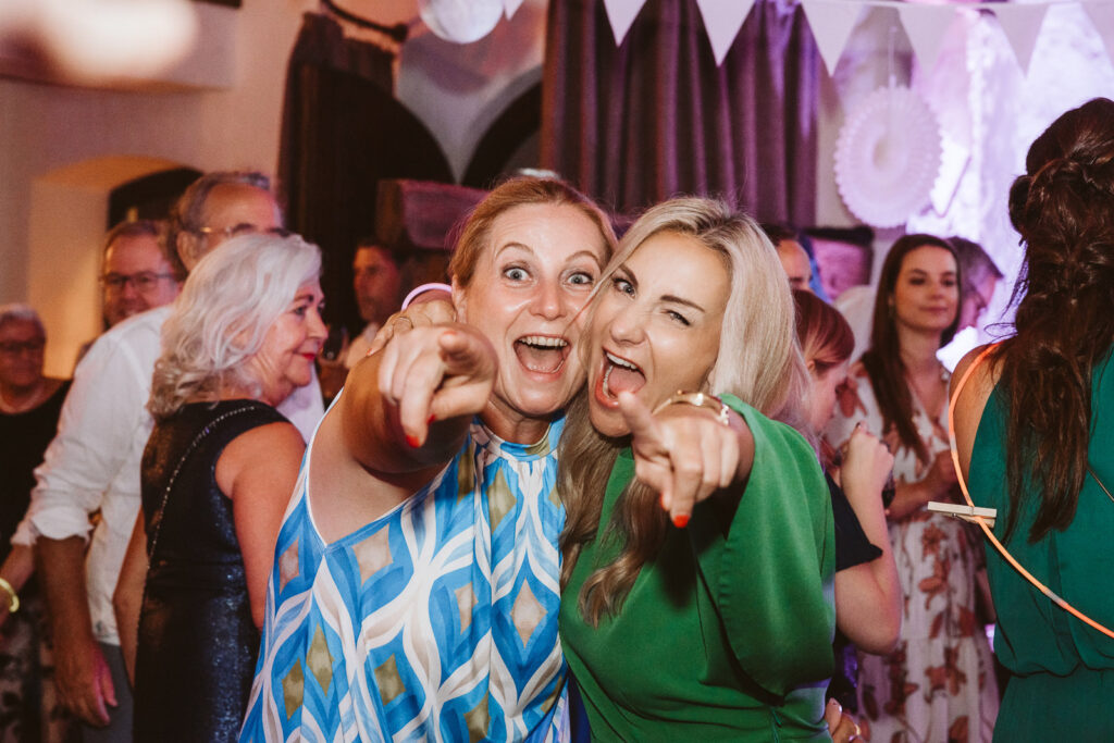 Hochzeitsgäste lachend auf der Tanzfläche der Hochzeit
