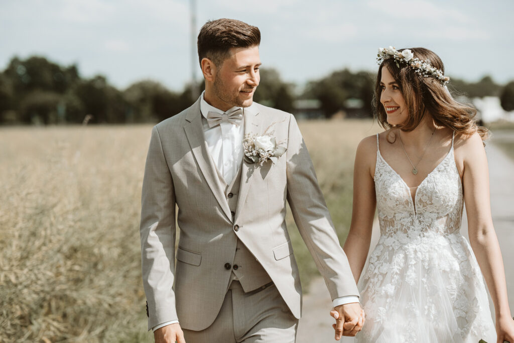 Brautpaar geht spazieren im Feld