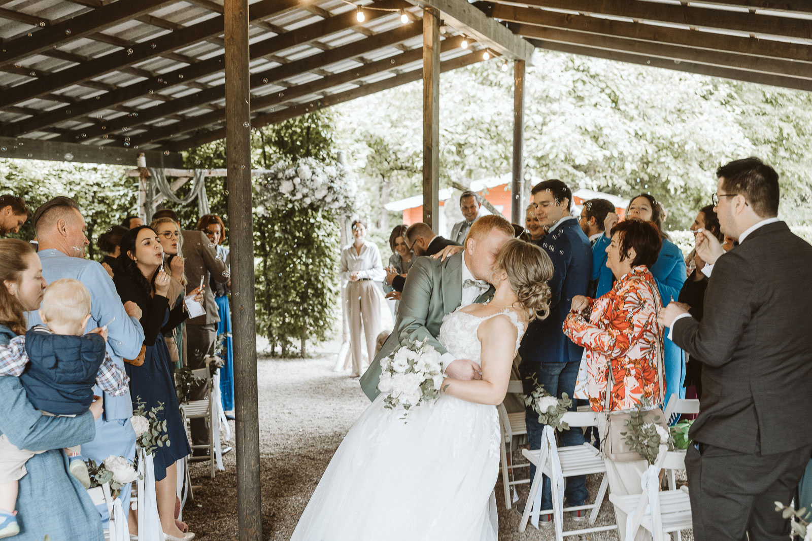 Kuss des Brautpaares mit den Hochzeitsgästen nach der Trauung