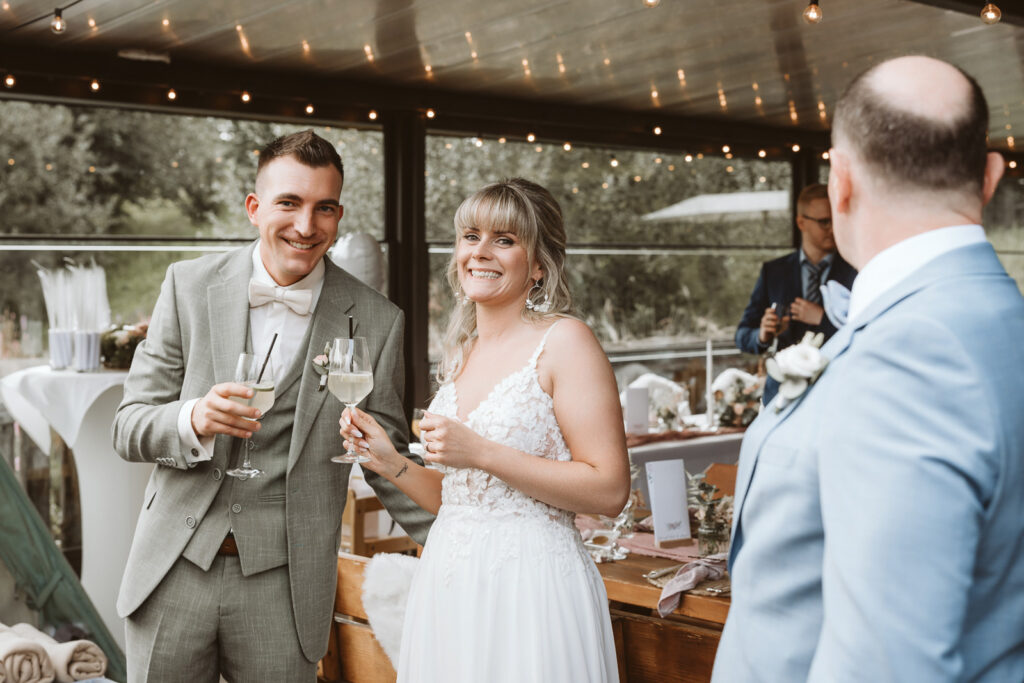 Brautpaar stößt mit Sekt auf ihre Hochzeit an